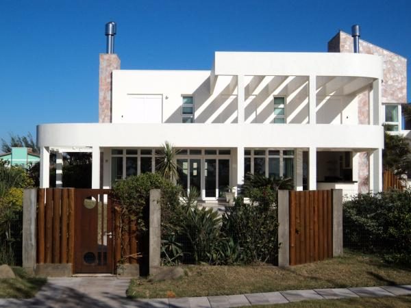 Residência litorânea com fachada curva pintada pela Arte Serra, projeto premiado entre as mais bonitas do litoral
