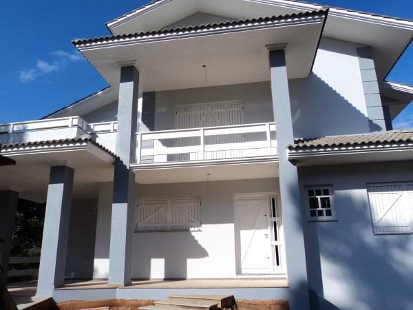 Residência de dois pavimentos com pintura externa e telhado colonial